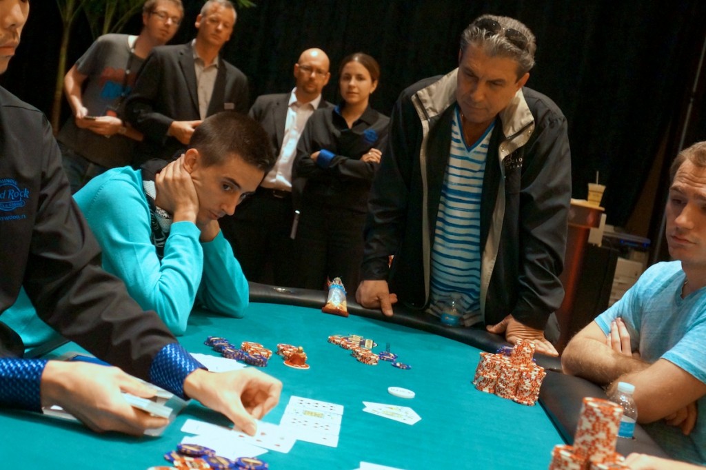 Samuel Bernabeu Guilabert (seated, left) watches the dealer put out the river card that will eliminate Panagiotis Nifakos (center) in seventh place.