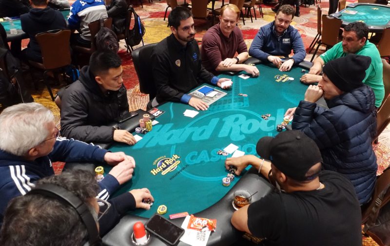 A wide-angle photo of all nine players at Table 22.