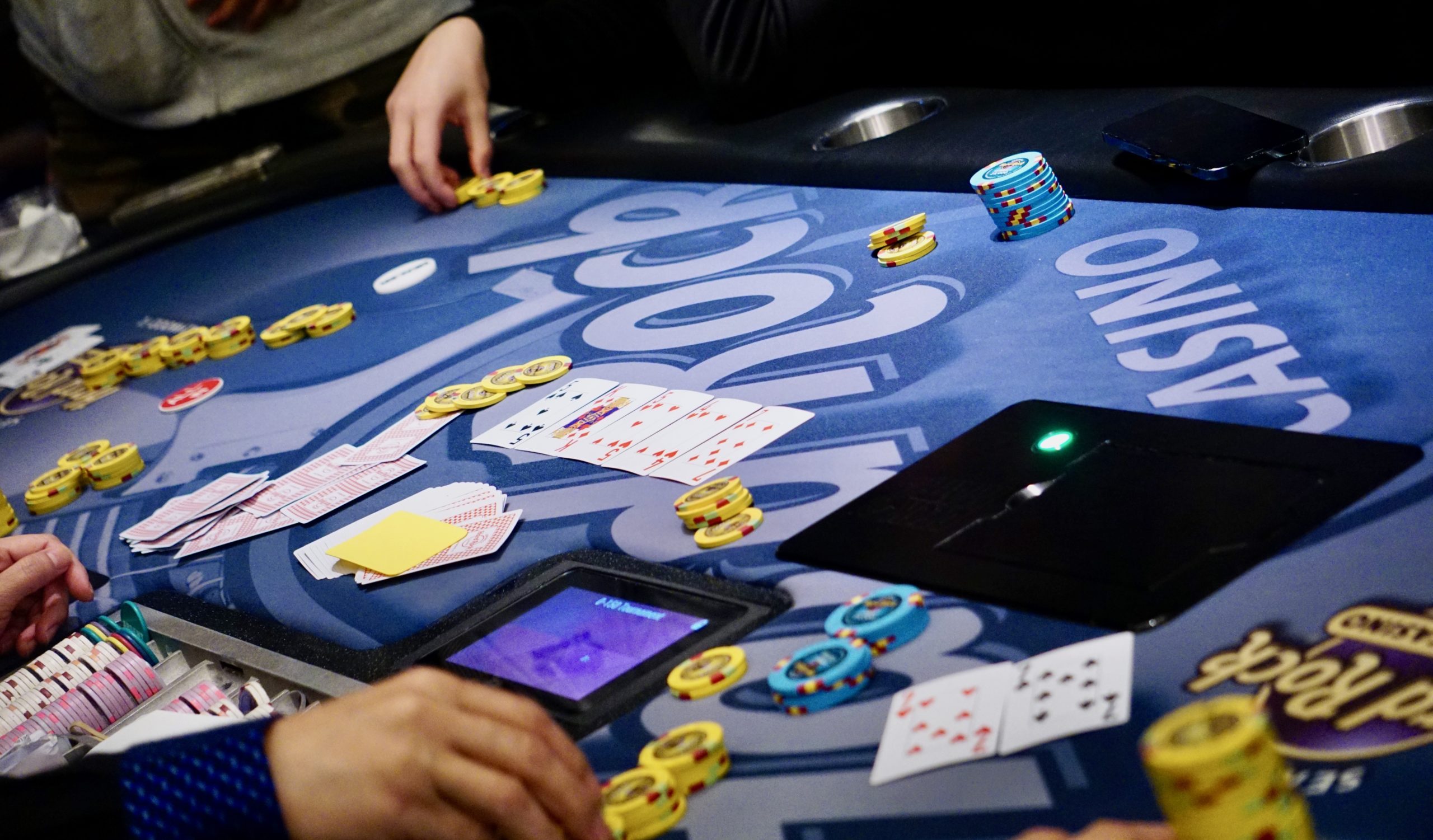 A poker table showing pocket sevens and a board with a 7 on the river.